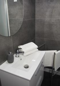 a bathroom with a white sink and a mirror at Apartamenty KopeX in Kostrzyn