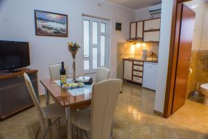 a kitchen and dining room with a table and chairs at DMM Apartments in Tivat