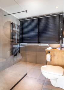 La salle de bains est pourvue de toilettes, d'une douche et d'un lavabo. dans l'établissement B&B Duinhuys, à Domburg