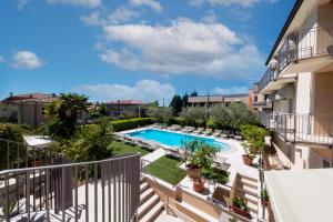 balcone con vista sulla piscina di un edificio di Hotel Al Sole Bardolino a Bardolino