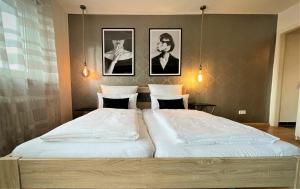 a bedroom with two beds and two pictures on the wall at Design Apartment Vendome in Freiburg im Breisgau