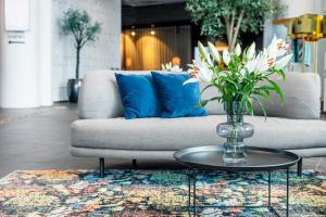 a glass vase with flowers on a table in a room at Clarion Hotel Malmö Live in Malmö