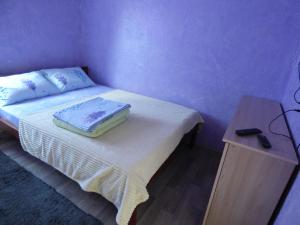 a small bedroom with a bed and a table at Приватна Садиба "У Оксани" in Pulʼmo