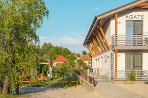 ein Gebäude mit einem Balkon und einem Baum in der Unterkunft Ubytovanie AGATE in Podhájska