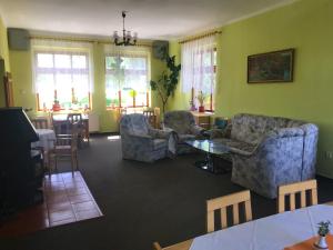 a living room with a couch and chairs and a table at Pension Berten Strašice in Strašice