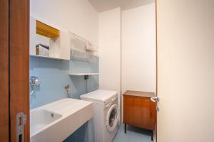 ein Badezimmer mit einer Waschmaschine und einem Waschbecken in der Unterkunft WePuglia - Casa sul Ponte in Polignano a Mare