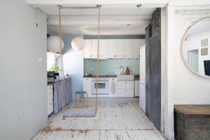 a kitchen with white cabinets and a swing at White Loft Stare Bielany Vintage Slow in Warsaw