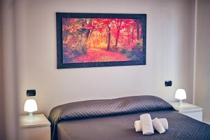 a bedroom with a bed and a painting on the wall at Travelershome 7Metri GuestHouse in Ciampino