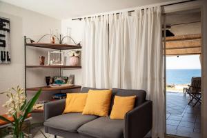 un soggiorno con divano e cuscini gialli di Casa Lugori a Torre Dei Corsari