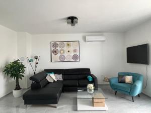 a living room with a black couch and a blue chair at Villa Eureka in Vodice