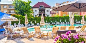a group of chairs and umbrellas next to a pool at Семеен хотел Анна-Кристина in Vidin