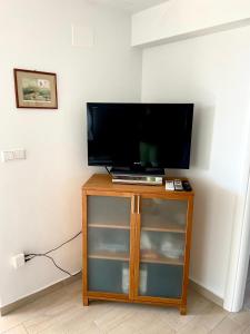 een flatscreen-tv op een houten standaard bij Villa Rudy Holiday Home in Njivice