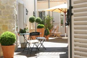 a patio with a table and chairs and an umbrella at Gîte Étoiles d'Orion 6 chambres in Marsolan