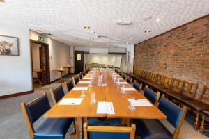 a long table in a room with chairs and a brick wall at Buffalo Bill's in Halland