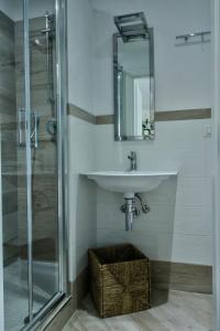 a bathroom with a sink and a glass shower at B&B Sea and Garden in Orbetello