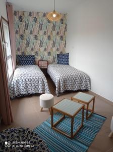 Cette petite chambre comprend deux lits et une table. dans l'établissement la ferme de fenivou, à Boulieu-lès-Annonay