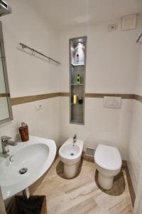 a bathroom with a white sink and a toilet at B&B Sea and Garden in Orbetello