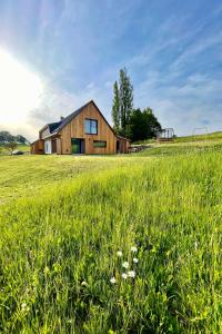 a house in the middle of a field of grass at Dead Fox Chalupa na samotě in Víchová nad Jizerou