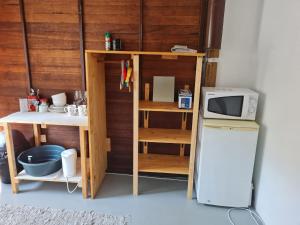 a small kitchen with a microwave and a refrigerator at DIE WAENHUIS in Swellendam