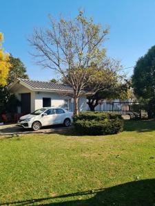 Un coche blanco aparcado delante de una casa en DIE WAENHUIS, en Swellendam