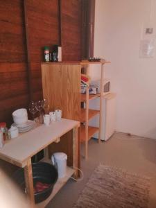 a kitchen with a table and a shelf with dishes at DIE WAENHUIS in Swellendam +7 photos