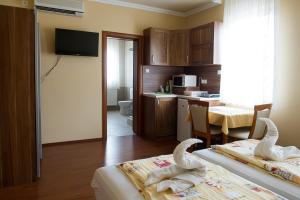una habitación de hotel con dos cisnes sentados en dos camas en Aura Apartman en Hajdúszoboszló