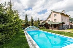 uma piscina no quintal de uma casa em Cottage Persona Lux em Slavske