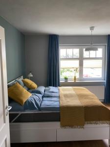 Un dormitorio con una cama con paredes azules y una ventana en Auszeit am Lindenpark, en Kühlungsborn