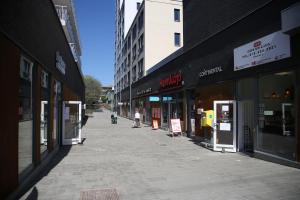 a person walking down a city street with buildings at Continental Apartment Hotel Sollentuna in Sollentuna