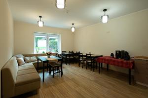 a living room with a couch and a table and chairs at Senasis Nemunas in Druskininkai