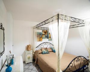 una camera con letto a baldacchino di Casa Lugori a Torre Dei Corsari