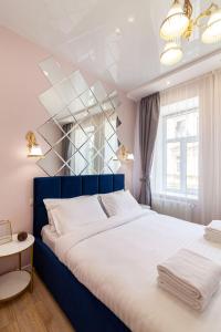 リヴィウにあるAvangard Magnus 10 Apartmentのベッドルーム1室(大型ベッド1台、青いヘッドボード付)