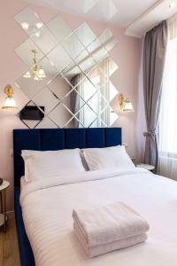 リヴィウにあるAvangard Magnus 10 Apartmentのベッドルーム1室(大型ベッド1台、青いヘッドボード付)