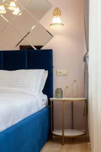 リヴィウにあるAvangard Magnus 10 Apartmentのベッドルーム(青いベッド1台、サイドテーブル付)