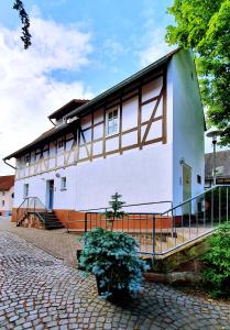 um grande edifício branco com uma cerca à volta em Zur Krone - Ferienhaus 2 em Widdershausen