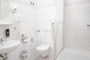 Hotel Astoria Stuttgart City في شتوتغارت: حمام ابيض مع مرحاض ومغسلة