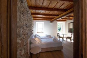 a bedroom with a bed and a stone wall at Casa Castagna 1620 in Mergozzo