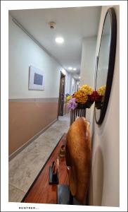 a hallway with a vase on a table with flowers at Le Petit Trianon et le Charme des Suites in Nice