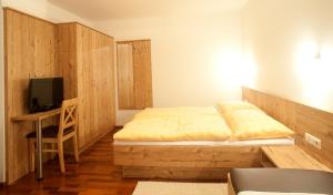 Schlafzimmer mit einem Bett und einem Schreibtisch mit einem TV in der Unterkunft Ferienhaus Deutschmann in St. Johann im Pongau