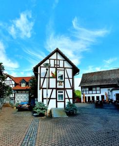 a black and white building on a brick street at Zur Krone - Ferienhaus 1 in Widdershausen