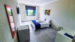 um pequeno quarto com uma cama e uma janela em Pousada Sal e Mar Maracaipe em Porto de Galinhas
