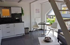 バースにあるFerienhaus Barth FDZ 031の白いキャビネット、テーブルと椅子付きのキッチンが備わります。