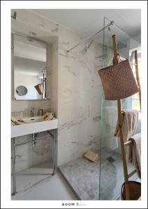 a bathroom with a sink and a mirror at Le Petit Trianon et le Charme des Suites in Nice