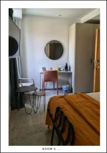 ニースにあるLe Petit Trianon et le Charme des Suitesのベッドルーム1室(ベッド1台、テーブル、椅子付)