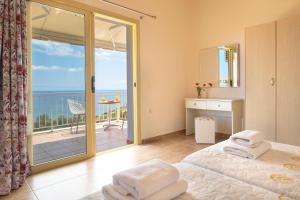 a bedroom with a bed and a view of the ocean at Astra Villas in Skala