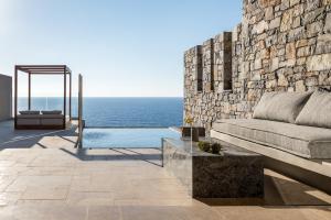 a living room with a couch and the ocean at Acro Suites - A Wellbeing Resort in Agia Pelagia