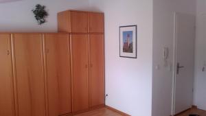 オストゼーバート・ゼリンにあるFewo im Seepark Sellinの白い壁の客室で、木製のキャビネットが備わります。
