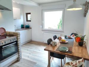 Webers Ferienwohnungen في Hilders: مطبخ مع طاولة وغرفة طعام +19 صورة