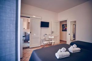 a bedroom with a bed with towels on it at Travelershome 7Metri GuestHouse in Ciampino