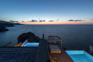 a view of the ocean from a house with a swimming pool at Acro Suites - A Wellbeing Resort in Agia Pelagia